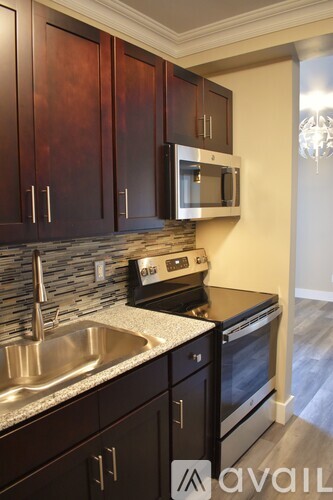 A kitchen with dark wood cabinets and stainless steel appliances.