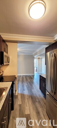 A kitchen with a refrigerator, sink, and cabinets.