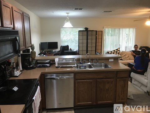 A kitchen with wooden cabinets and a stainless steel dishwasher.