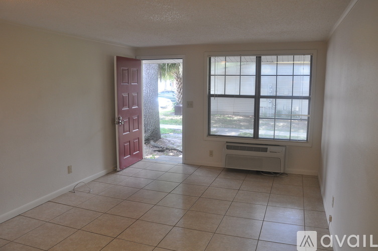 A room with a red door and a window with blinds.