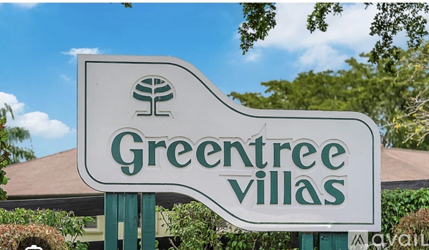 A sign for Greentree Villas with a tree logo on it.