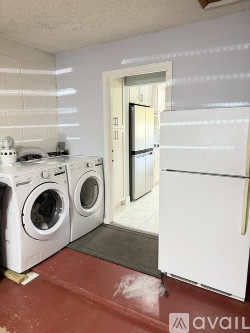 A room with a washer and dryer and a refrigerator.
