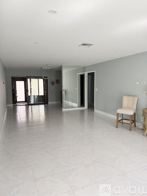 A spacious room with a chair and a table.