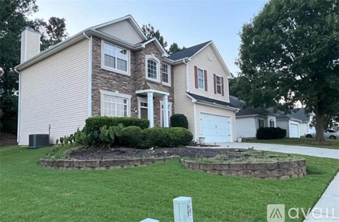 A two-story house with a garage and a landscaped front yard.