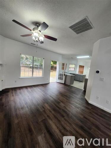 A room with wooden floors and a ceiling fan.