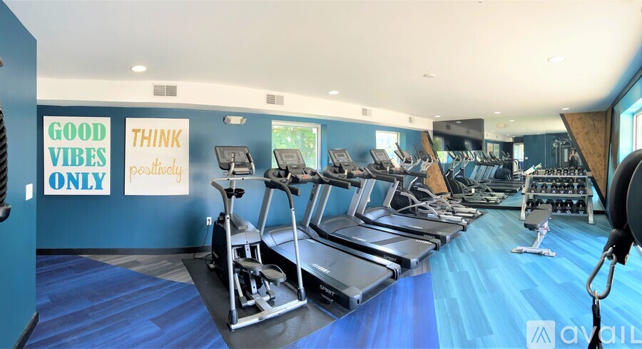 A gym with treadmills and a sign that says "Good Vibes Only".