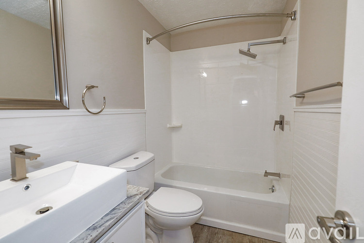 A white bathroom with a toilet, sink, and bathtub.