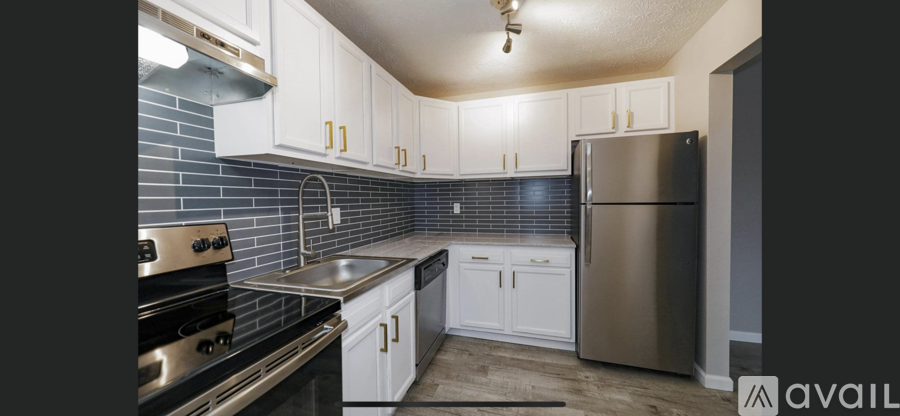 A kitchen with white cabinets and a stainless steel refrigerator.