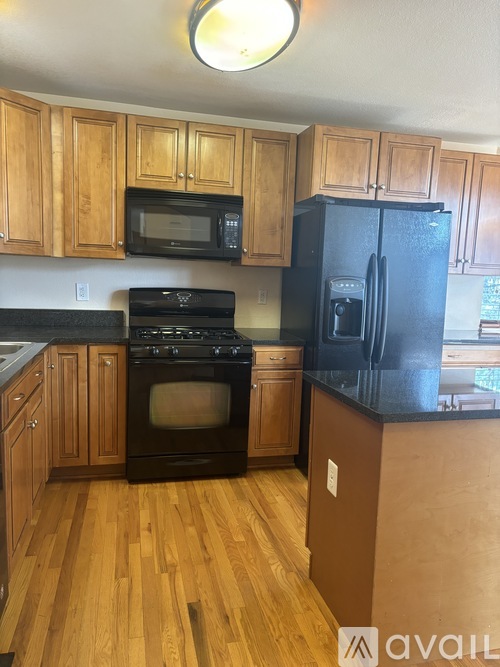 A kitchen with wooden cabinets and black appliances.