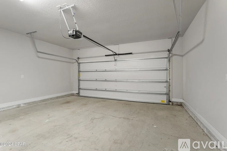 A spacious garage with a white door and a ceiling light.