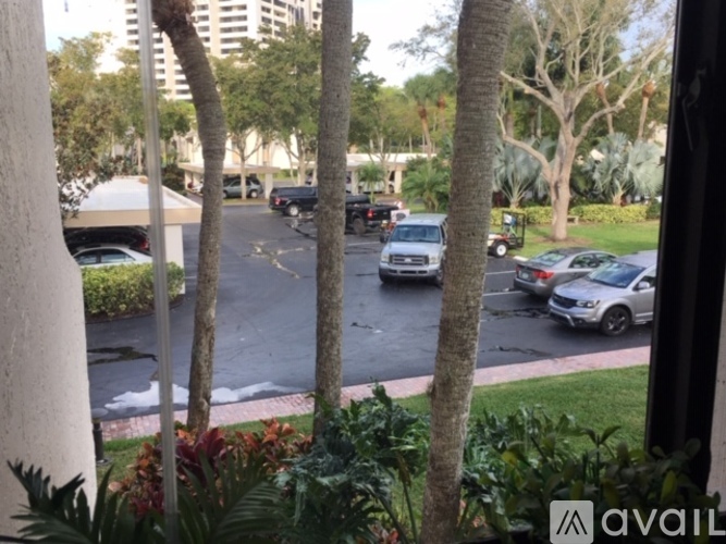A parking lot with cars and trees.