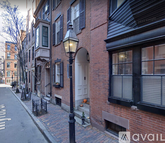 A street view of a building with a black lamp post in front.