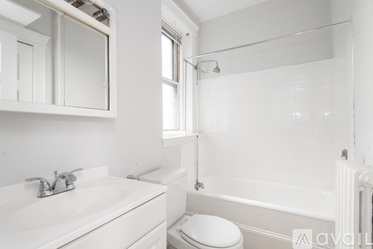 A white bathroom with a toilet, sink, and bathtub.