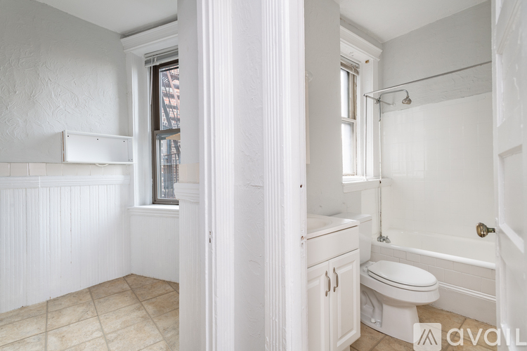A white bathroom with a toilet, sink, and bathtub.