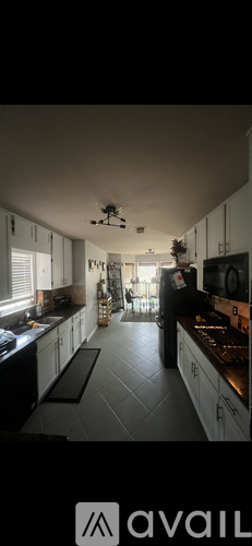 A kitchen with black appliances and white cabinets.