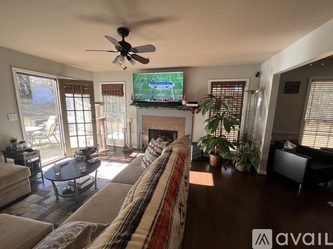 A living room with a television mounted above a fireplace.
