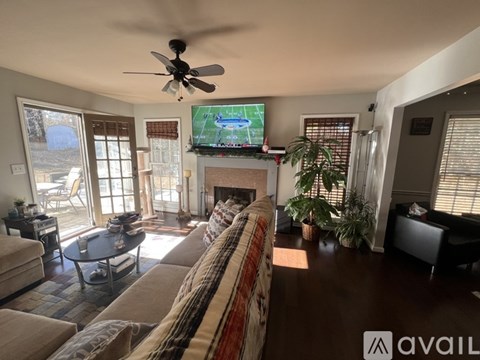 A living room with a television mounted above a fireplace.