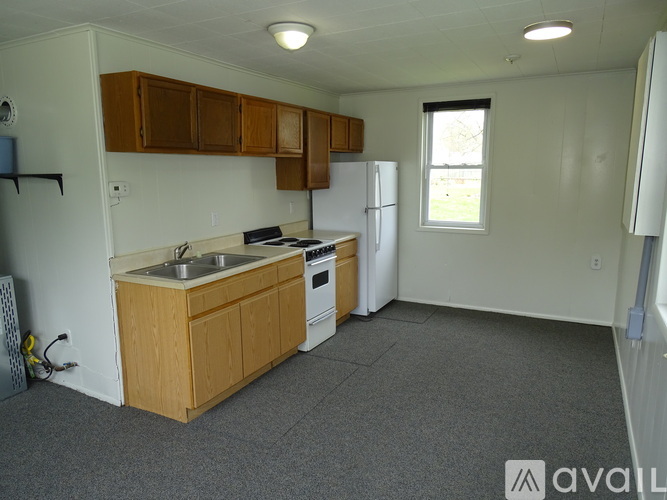 A kitchen with wooden cabinets and a white refrigerator.