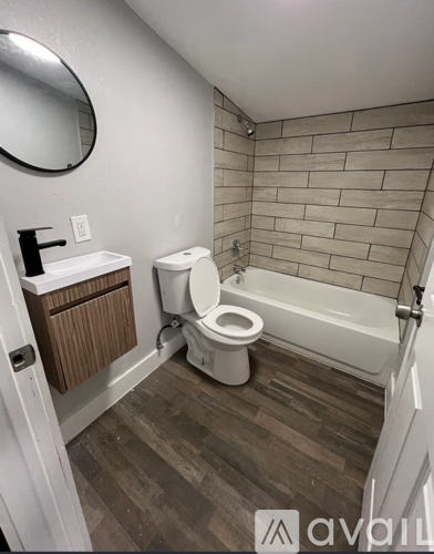 A bathroom with a toilet, sink, and bathtub.