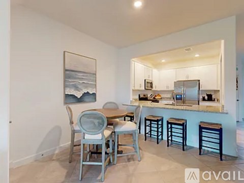 A kitchen with a dining table and chairs.