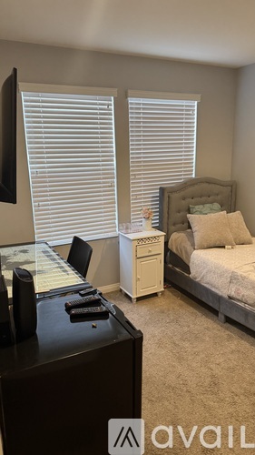 A bedroom with a bed, nightstand, and chair.