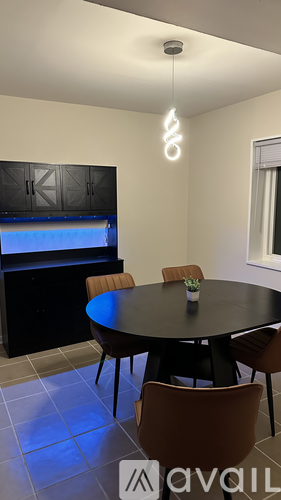 A spacious room with a carpeted floor and a large window with a view of the outdoors.