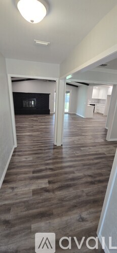A spacious room with wooden flooring and a white ceiling.