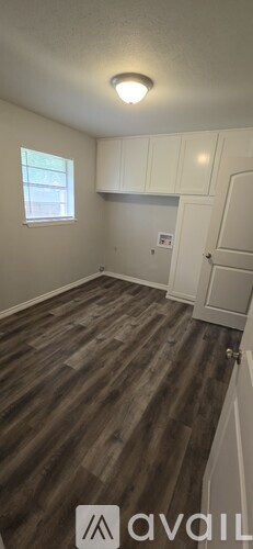 A room with wooden flooring and white walls.