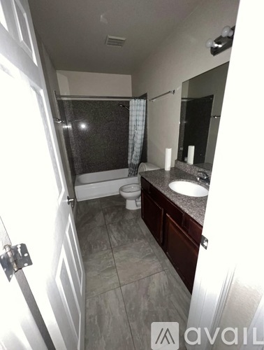 A bathroom with a toilet, sink, and shower.