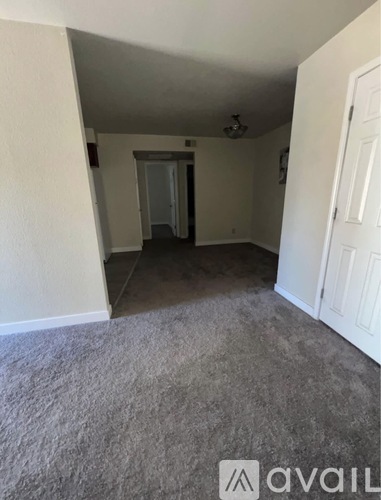 A room with a carpeted floor and a door on the right.