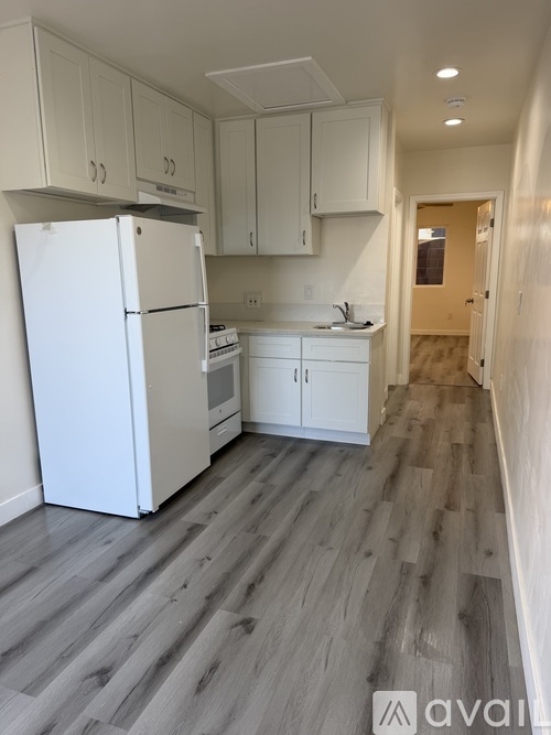 A kitchen with white appliances and cabinets.