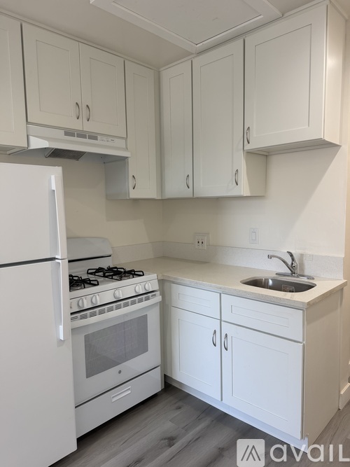 A kitchen with white appliances and cabinets.