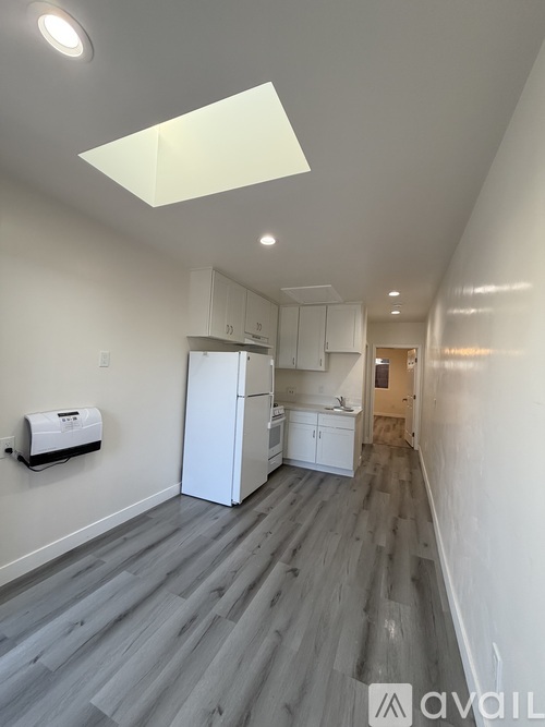 A kitchen with white cabinets and a white refrigerator.