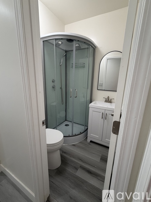A bathroom with a toilet, sink, and shower.