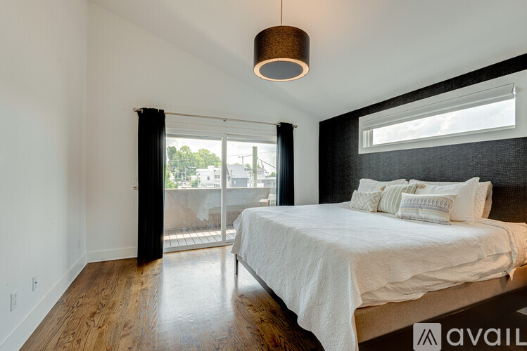 A bedroom with a large bed and a sliding glass door.