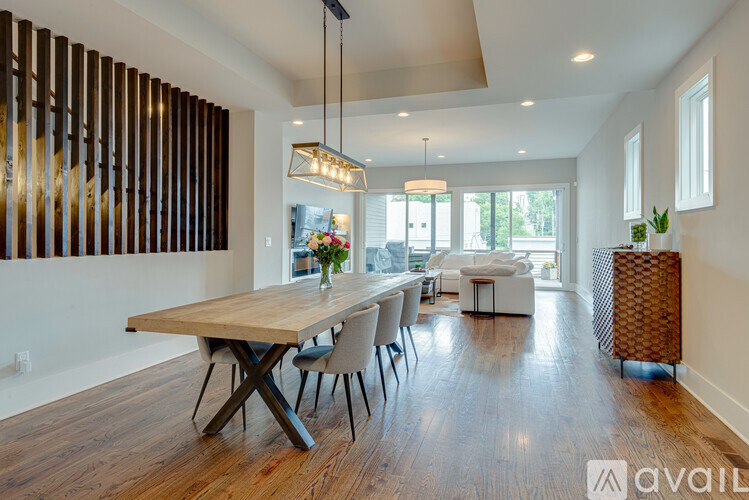 A modern dining room with a wooden table and chairs.