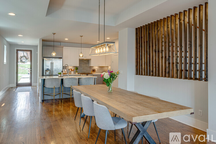 A modern kitchen with a wooden table and chairs.