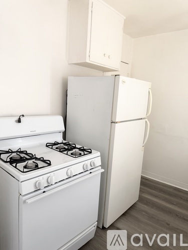 A white gas stove and refrigerator in a kitchen.