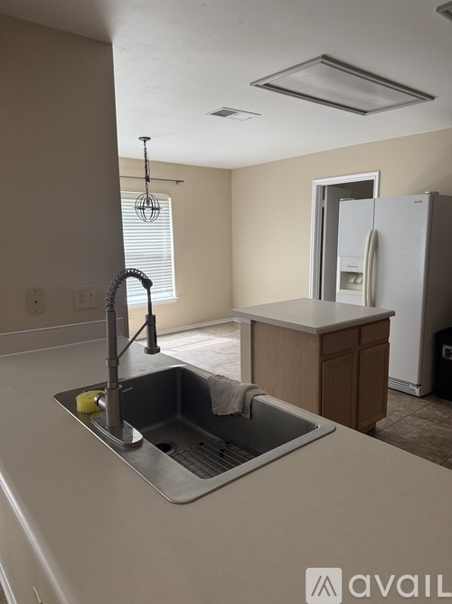 A kitchen with a sink and a refrigerator.