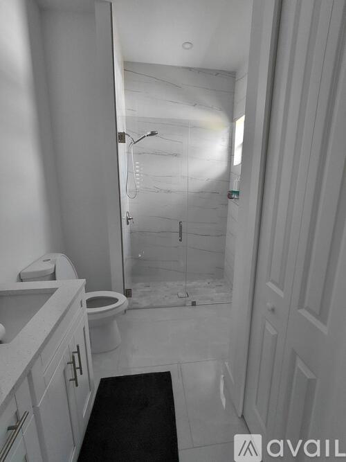 A bathroom with a toilet, sink, and shower.