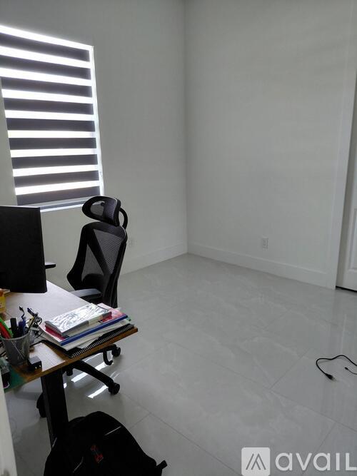 A room with a desk, chair, and a computer monitor.