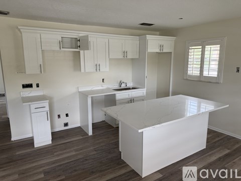 A kitchen with white cabinets and a marble countertop.