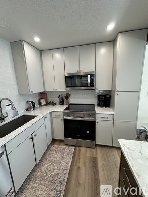 A kitchen with white cabinets and a sink.