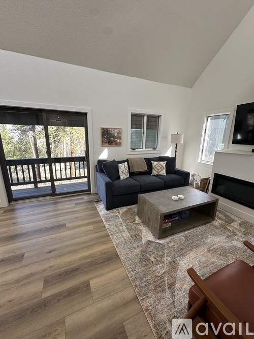 A living room with a couch, coffee table, and a fireplace.