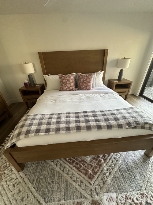 A bed with a checkered comforter and pillows is in the image.
