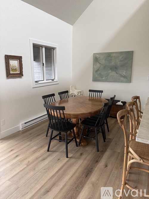A dining room with a wooden table and chairs.