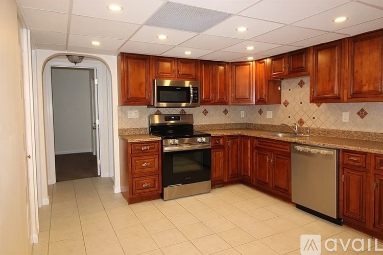 A kitchen with brown cabinets and a tiled backsplash.