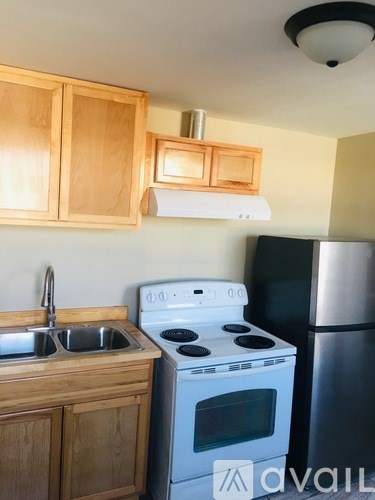 A kitchen with wooden cabinets and a white stove top oven.
