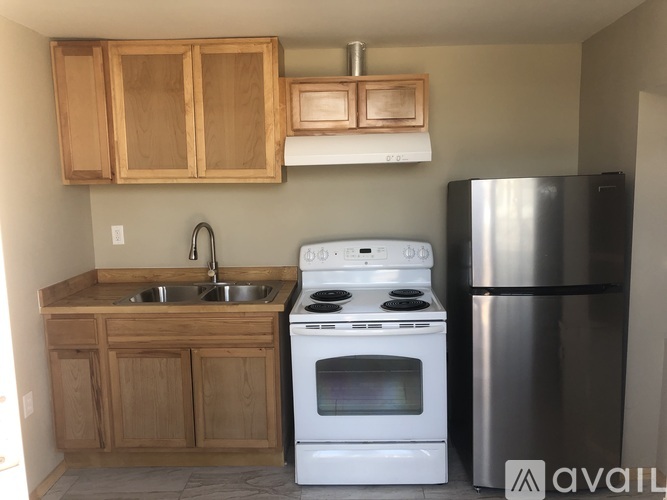 A kitchen with wooden cabinets and a white stove.