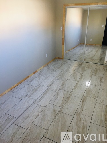 A room with marble tiles flooring and a wooden door.